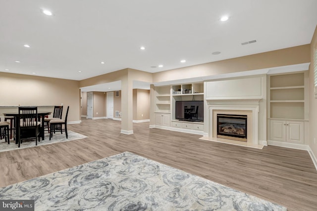 12723 Lady Somerset Ln, Fairfax, VA 22033 - living area featuring baseboards, light wood-style flooring, built in features, a glass covered fireplace, and recessed lighting