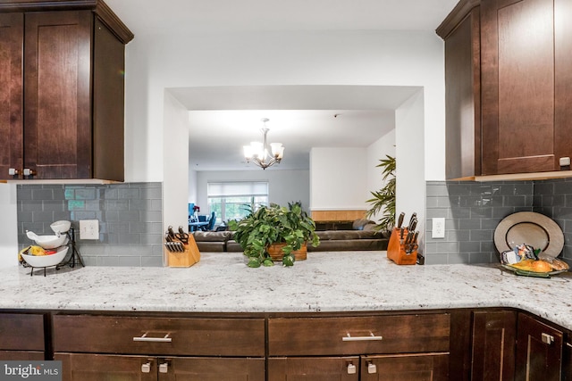 9213 Fairlane Pl, Laurel, MD 20708 - kitchen featuring tasteful backsplash, a chandelier, dark brown cabinetry, light stone countertops, and open floor plan