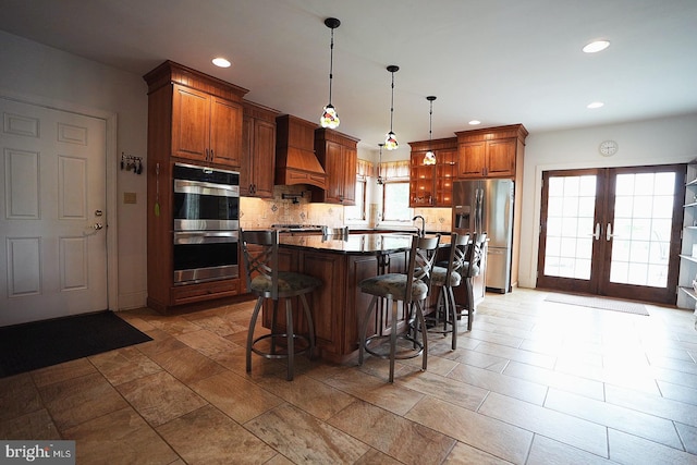 663 Tomlin Station Rd, Mullica Hill, NJ 08062 - kitchen with stainless steel appliances, custom range hood, tasteful backsplash, a sink, and a kitchen breakfast bar