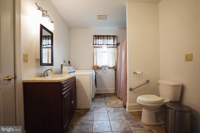 663 Tomlin Station Rd, Mullica Hill, NJ 08062 - full bathroom with washer and dryer, vanity, toilet, stone tile flooring, and baseboards