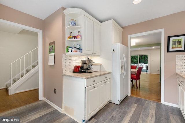kitchen with white fridge with ice dispenser, dark wood-style floors, open shelves, and white cabinetry