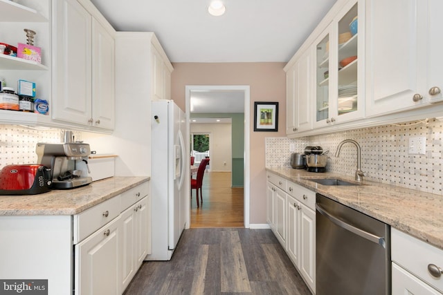 kitchen with stainless steel dishwasher, white fridge with ice dispenser, a sink, dark wood-style floors, and white cabinetry
