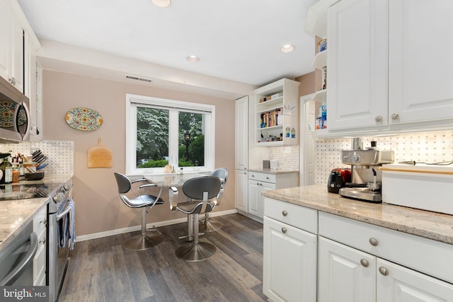 kitchen featuring stainless steel appliances, backsplash, dark wood-style flooring, white cabinets, and recessed lighting