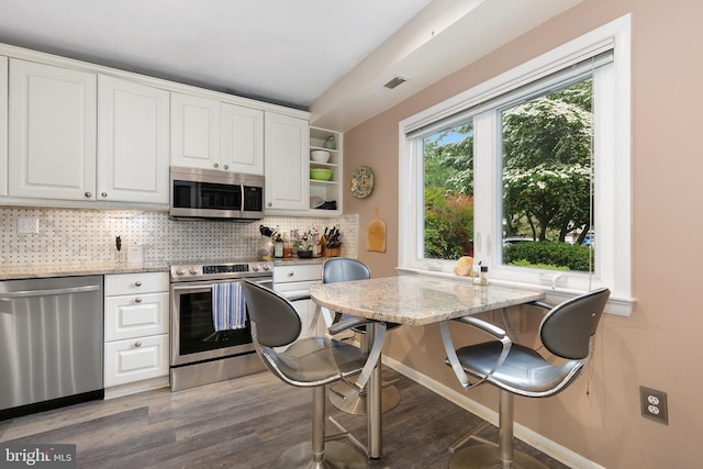 kitchen featuring stainless steel appliances, white cabinetry, and wood finished floors