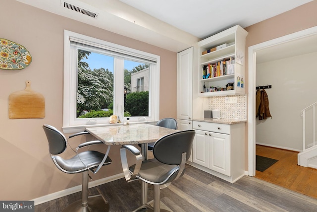dining space featuring wood finished floors and baseboards