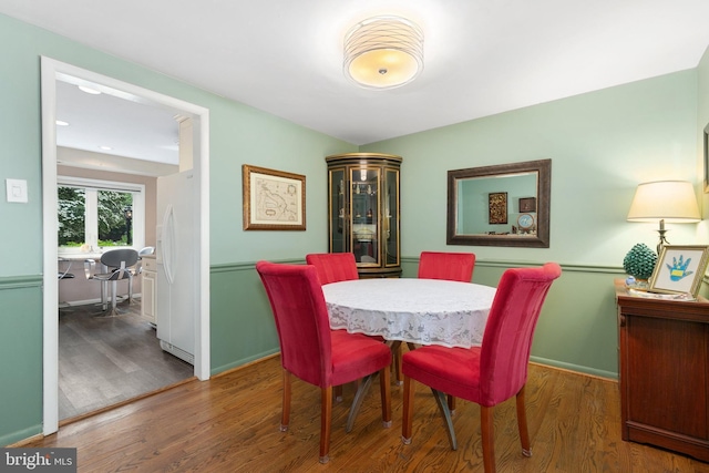 dining space with wood finished floors and baseboards