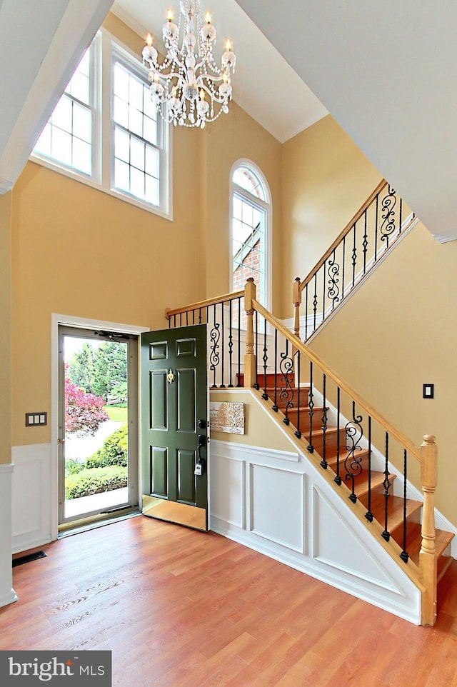 15420 Cedarhurst Ct, Centreville, VA 20120 - entryway featuring a chandelier, wood finished floors, a high ceiling, a wainscoted wall, and a decorative wall