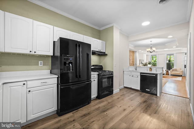 326 E 28th St, Baltimore, MD 21218 - kitchen featuring black appliances, a chandelier, a sink, ornamental molding, and wood finished floors