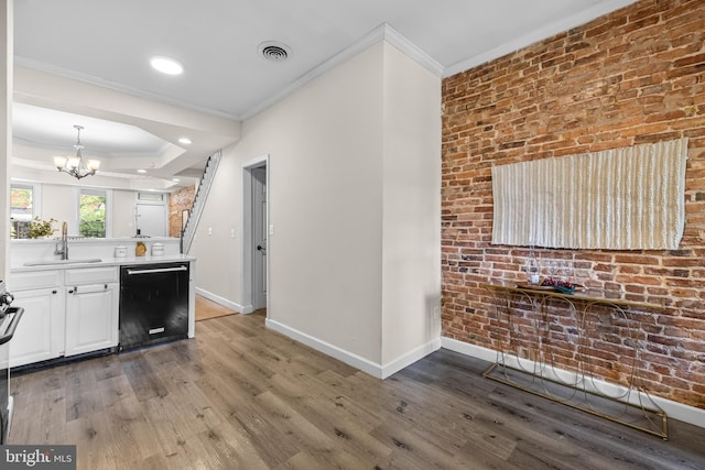 326 E 28th St, Baltimore, MD 21218 - kitchen with dishwasher, a sink, baseboards, crown molding, and a chandelier
