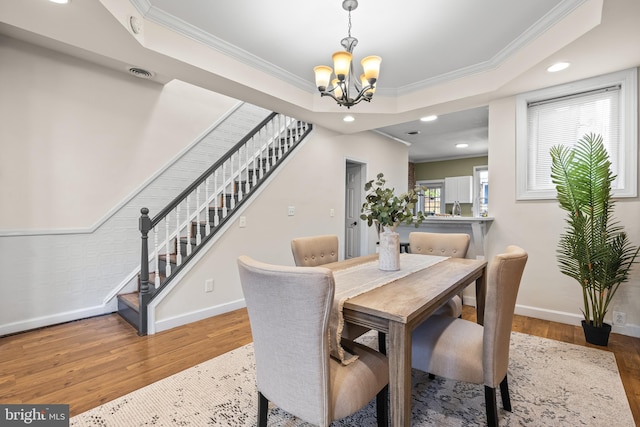326 E 28th St, Baltimore, MD 21218 - dining area with stairs, crown molding, a chandelier, wood finished floors, and baseboards