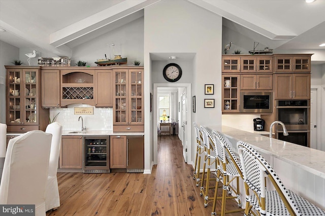 29325 Andrew Jackson Dr, Millsboro, DE 19966 - indoor wet bar with beverage cooler, stainless steel appliances, light wood-type flooring, tasteful backsplash, and high vaulted ceiling