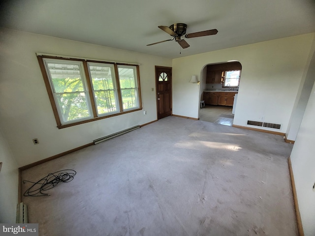 155 Hyndman Rd, Hyndman, PA 15545 - unfurnished living room featuring baseboard heating, a ceiling fan, arched walkways, and baseboards