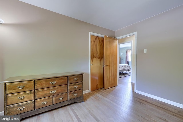 bedroom with baseboards and light wood finished floors