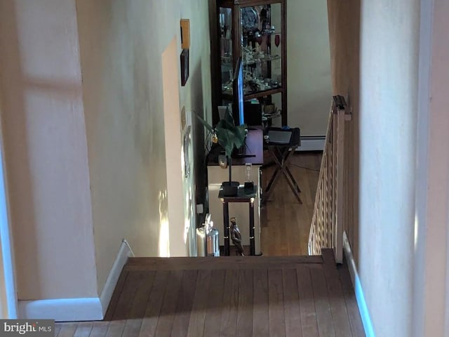 hall with wood finished floors, baseboards, and a baseboard radiator