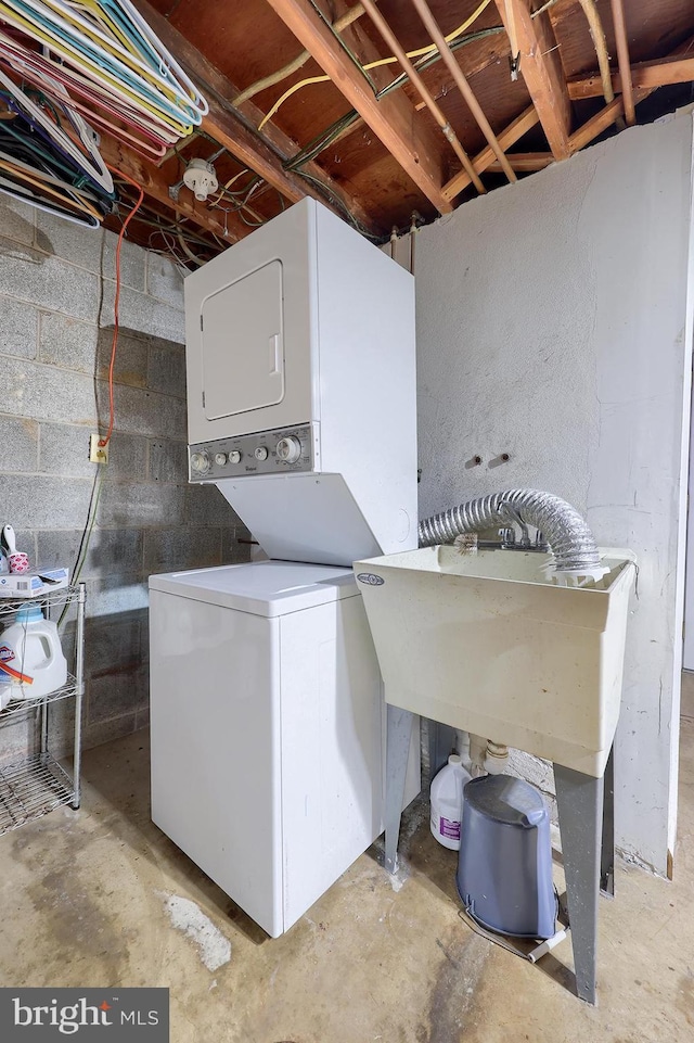 clothes washing area with estacked washer and dryer