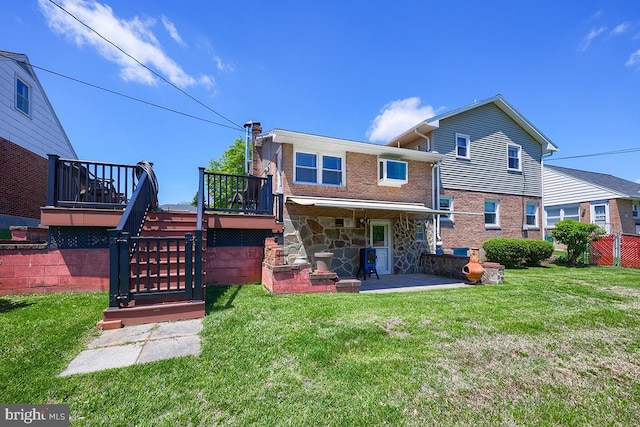 back of house with stairs, a patio, a wooden deck, brick siding, and stone siding