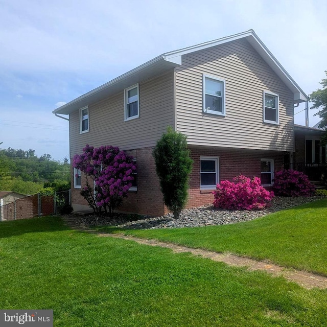 view of side of property with brick siding and a yard