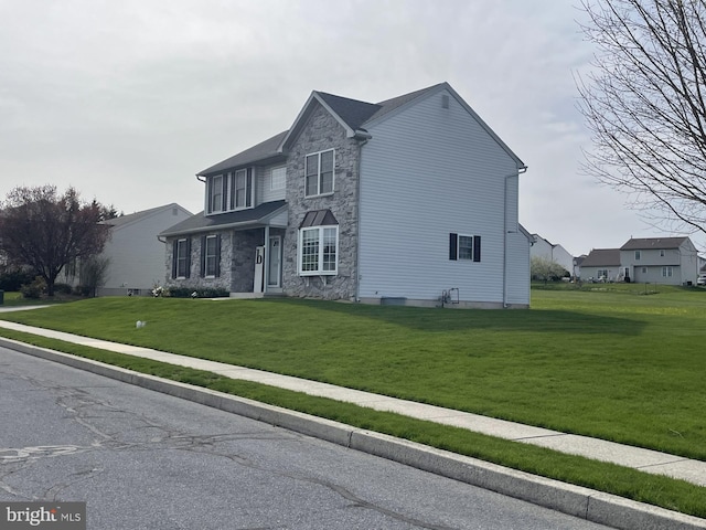 traditional-style home with stone siding and a front lawn