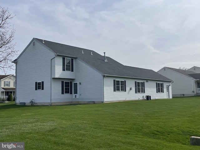 rear view of property with a yard and central AC unit