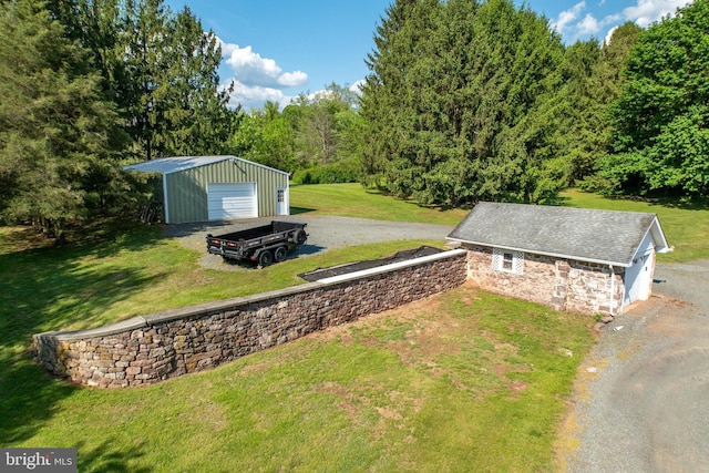 305 Gunhart Rd, Mohnton, PA 19540 - view of green lawn featuring an outdoor structure, gravel driveway, a garage, and a view of trees
