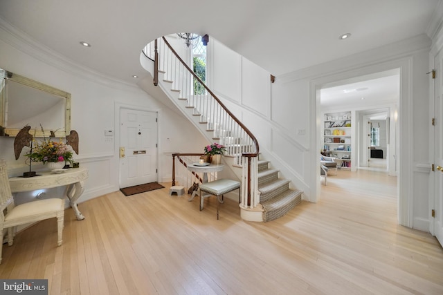5033 Tilden St NW, Washington, DC 20016 - entryway featuring stairway, light wood finished floors, crown molding, a decorative wall, and recessed lighting