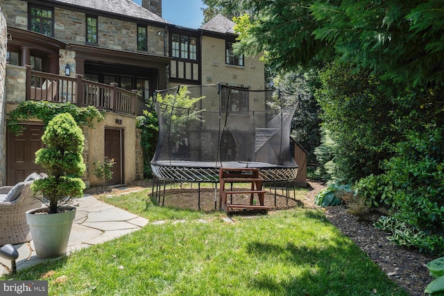 5033 Tilden St NW, Washington, DC 20016 - back of property with a trampoline, a lawn, a high end roof, and stucco siding