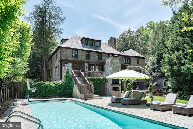 5033 Tilden St NW, Washington, DC 20016 - rear view of house featuring stone siding, a chimney, a patio area, and stairway