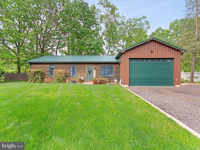 view of front of home featuring driveway, an attached garage, and metal roof