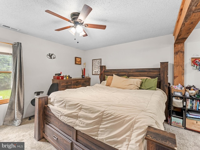 bedroom with light carpet, a textured ceiling, and a ceiling fan