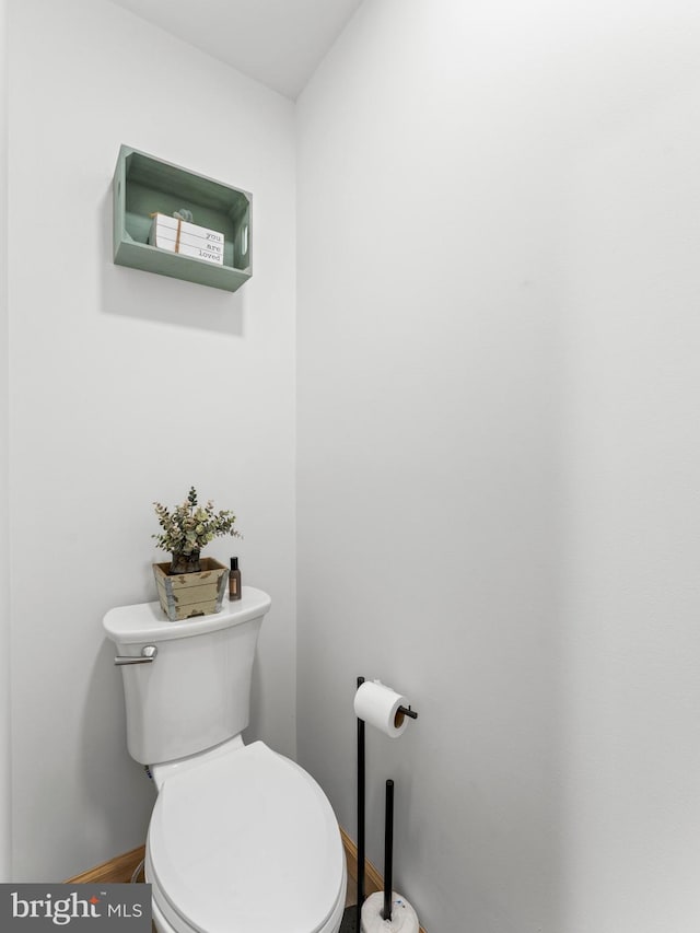 bathroom with baseboards, toilet, and wood finished floors