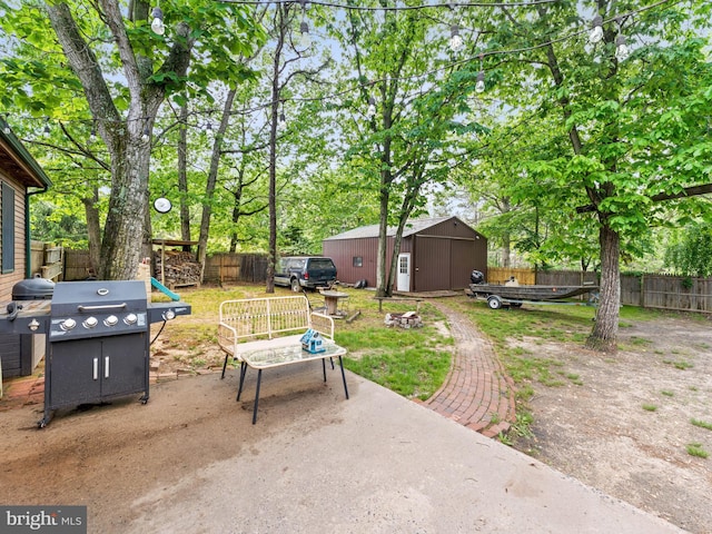 view of patio featuring a fenced backyard, an outbuilding, and an outdoor fire pit