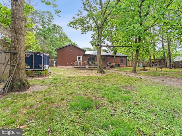 view of yard with a deck, an outbuilding, and exterior structure