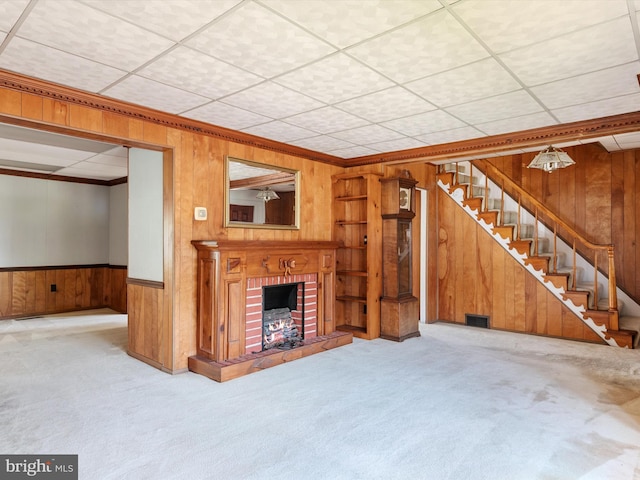 108 S 2nd St, Denton, MD 21629 - unfurnished living room with wooden walls, carpet flooring, stairway, a brick fireplace, and ornamental molding