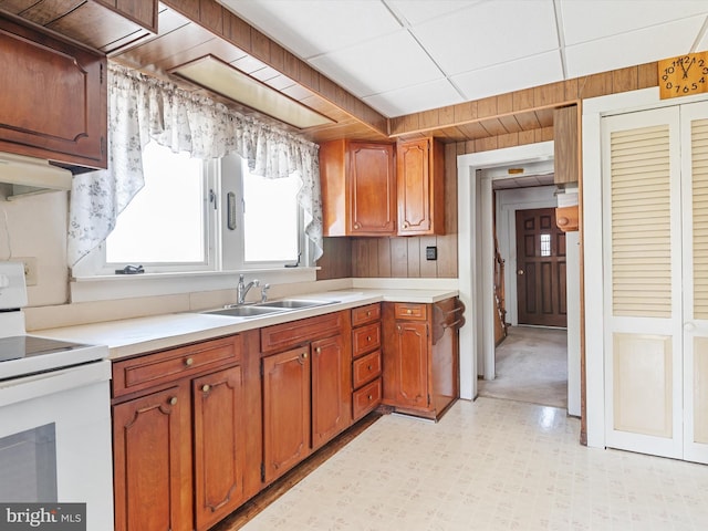108 S 2nd St, Denton, MD 21629 - kitchen with white electric range, a sink, light countertops, light flooring, and wooden walls