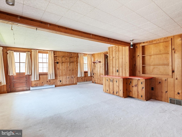 108 S 2nd St, Denton, MD 21629 - unfurnished living room featuring wooden walls, baseboard heating, and carpet floors