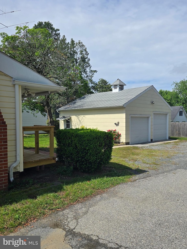 view of side of home with a garage and an outbuilding
