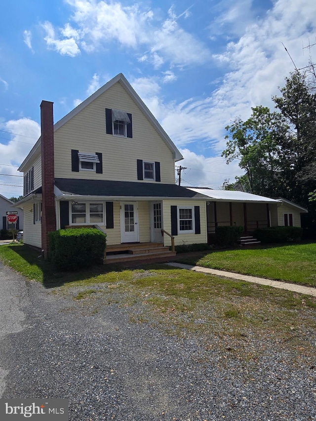 view of front facade featuring a chimney and covered porch