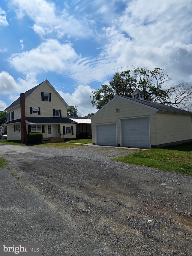 view of side of home with a detached garage and an outdoor structure