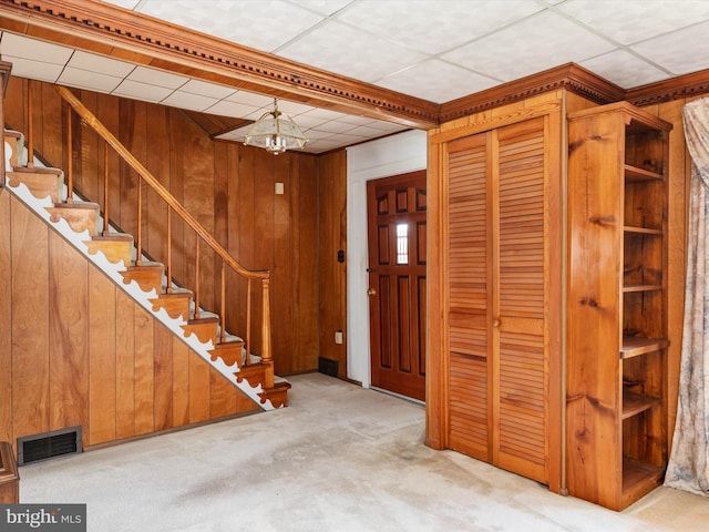108 S 2nd St, Denton, MD 21629 - carpeted entryway featuring wood walls, stairs, and a chandelier
