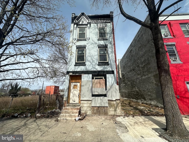 view of front of house featuring fence, a chimney, and entry steps