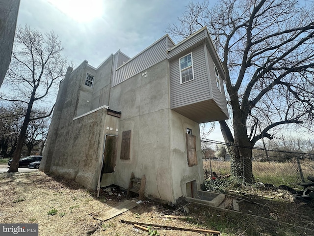 view of home's exterior with fence and stucco siding