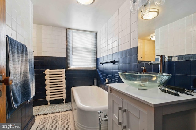 247 W Walnut St, Shamokin, PA 17872 - bathroom featuring tile walls, a tub to relax in, vanity, and tile patterned flooring