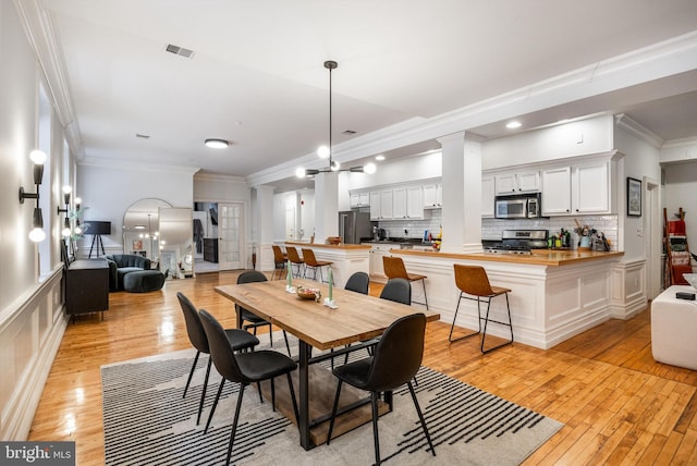 237 N Bread St Unit 2, Philadelphia, PA 19106 - dining area featuring light wood-style flooring, ornamental molding, and decorative columns