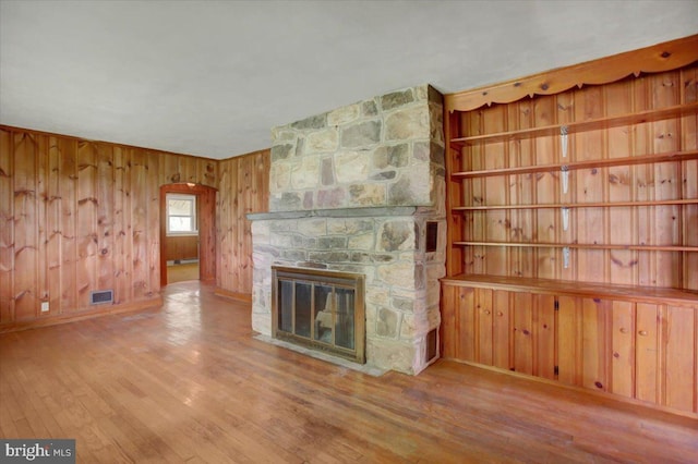129 Shippensburg Rd, Shippensburg, PA 17257 - unfurnished living room featuring a fireplace, wood finished floors, wood walls, and arched walkways