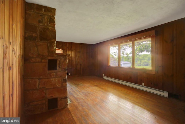 129 Shippensburg Rd, Shippensburg, PA 17257 - unfurnished living room with a baseboard heating unit, hardwood / wood-style floors, and wooden walls