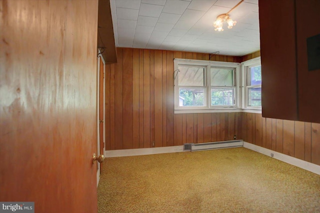 129 Shippensburg Rd, Shippensburg, PA 17257 - spare room featuring a baseboard heating unit, carpet flooring, wood walls, and baseboards