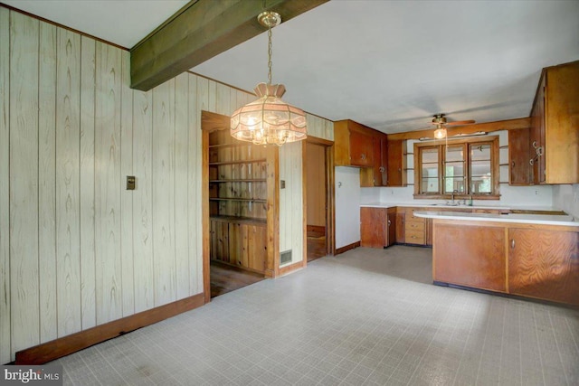 129 Shippensburg Rd, Shippensburg, PA 17257 - kitchen with wooden walls, brown cabinets, a chandelier, light countertops, and a sink