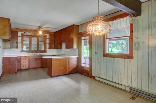 129 Shippensburg Rd, Shippensburg, PA 17257 - kitchen featuring a baseboard radiator, a sink, brown cabinetry, a chandelier, and wood walls
