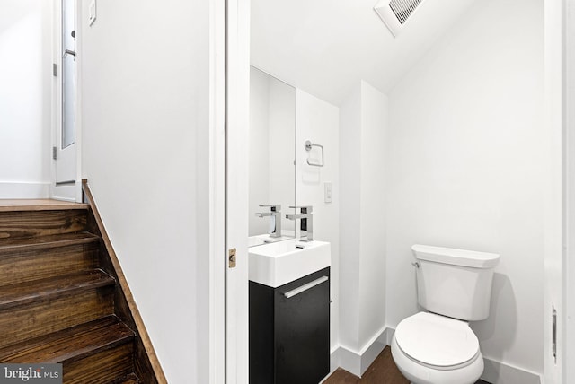 1339 S Garnet St, Philadelphia, PA 19146 - half bathroom featuring toilet, vanity, baseboards, and lofted ceiling