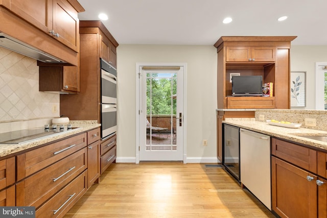 1802 24th St S, Arlington, VA 22202 - kitchen with black electric stovetop, dishwashing machine, light wood-style flooring, decorative backsplash, and premium range hood